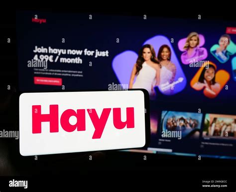 Person Holding Smartphone With Logo Of Us Video Streaming Company Hayu