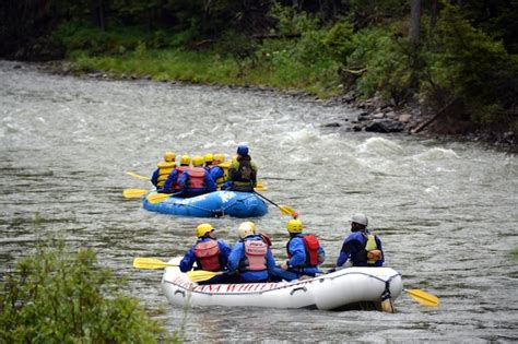 Premium Photo | Rear view of people rafting in gallatin river