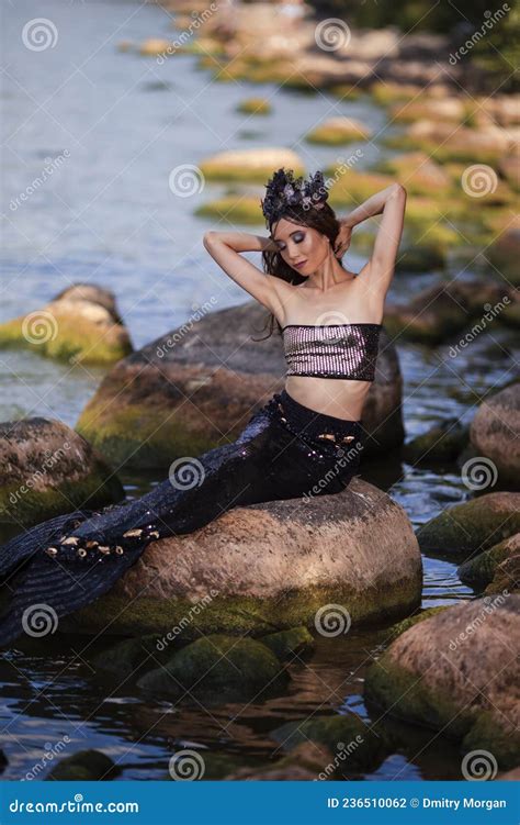 Asian Mermaid Posing at Ocean Shore on Rocks while Wearing Seashell ...
