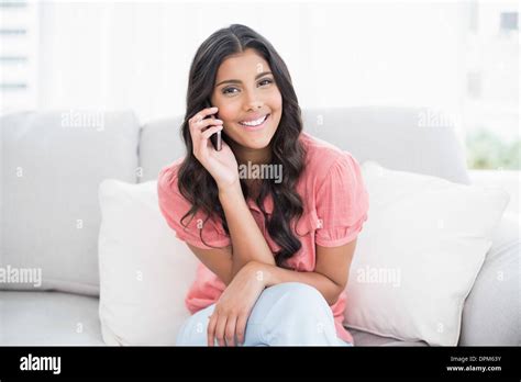 Cheerful Cute Brunette Sitting On Couch Phoning Stock Photo Alamy