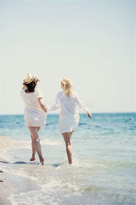 Les Filles Heureuses Qui Courent Sur La Plage De La Mer Image Stock