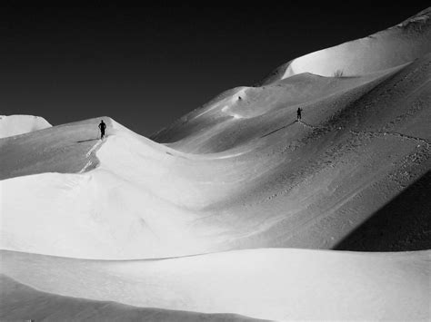 Two people skiing down a snow covered mountain photo – Free Grey Image