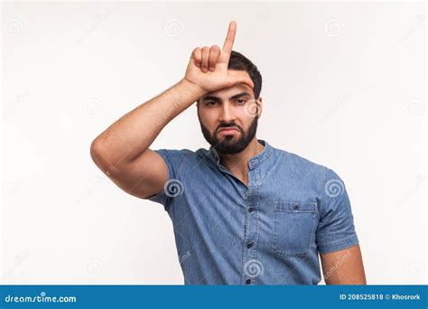 Unhappy Depressed Man With Beard In Blue Shirt Holding Hand Near