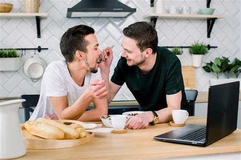 Pareja Gay Masculina Sentado En La Mesa Y Desayunando En Su Cocina Apuesto Joven En Camiseta