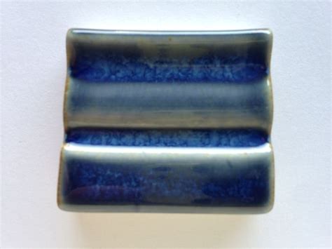 A Blue And Silver Object On A White Wall With No One In The Photo