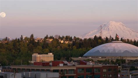 A Full Moon Appears On The Horizon Near Mt Rainier And The Tacoma Dome