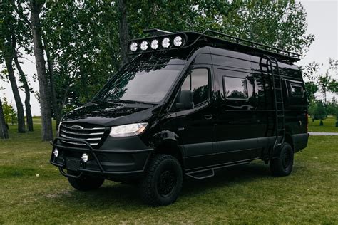 a black van is parked in the grass