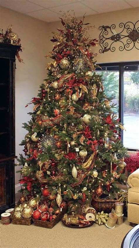 A Christmas Tree Is Decorated With Red Gold And Silver Ornaments In A