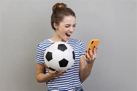 Woman Holding Soccer Ball And Smart Phone Betting And Winning