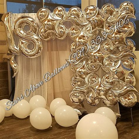 Some Balloons Are Sitting In Front Of A Large Balloon Arch