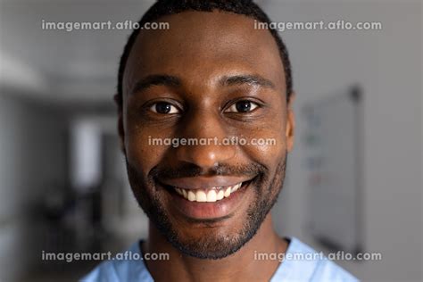 Portrait Of Happy African American Male Doctor Wearing Scrubs In