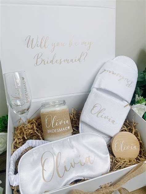 A White Box Filled With Personalized Items For Bridesmaids And Groomsmid