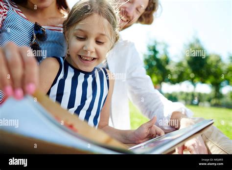 Reading with parents Stock Photo - Alamy