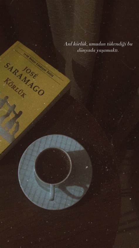 A Cup Of Coffee Sitting On Top Of A Table Next To A Book