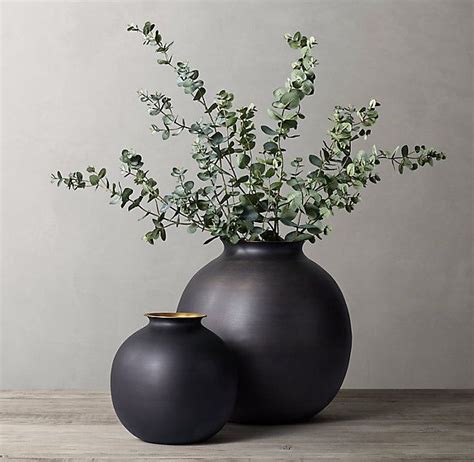 Two Black Vases With Green Plants In Them