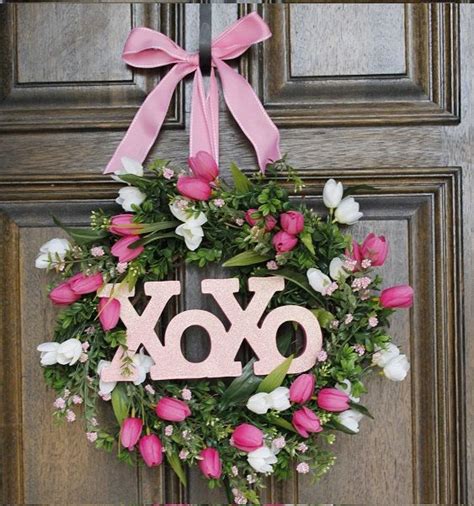 A Pink Wreath With The Word Joy Hanging From It S Side On A Door