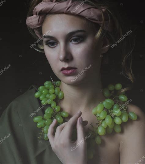 Portrait girl with scarf on head and grapes and onу naked breast Stock