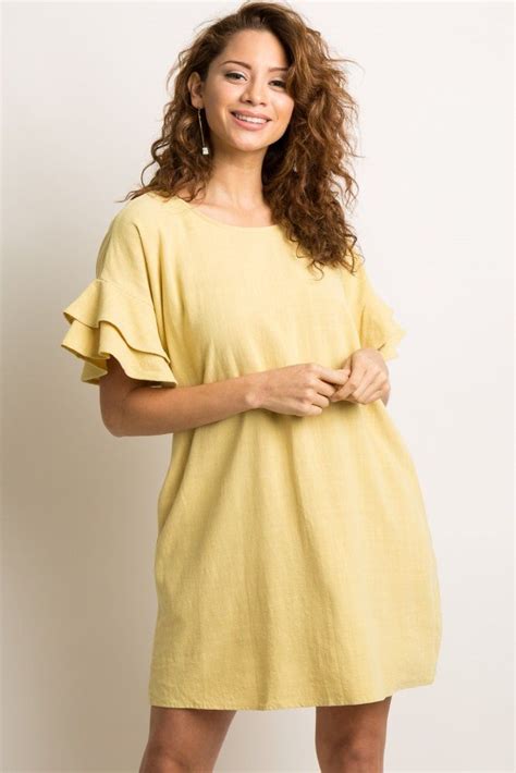 A Lightweight Linen Shift Dress Featuring Short Sleeves With A Layered Ruffle Trim And Side