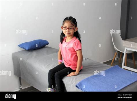 4 Year Old Brunette Latina Girl Sitting On The Bed In A Doctor S Office Nervous Scared Because