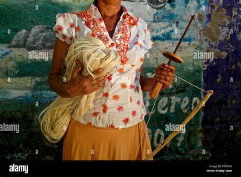 Mujer indígena Kankuamo sujetando el tricotaje carrumba herramienta y