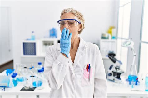 Middle Age Blonde Woman Working At Scientist Laboratory Bored Yawning