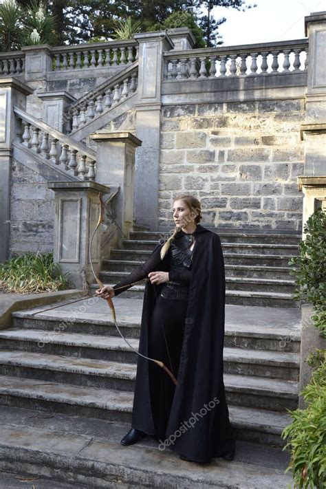 Portrait Of Beautiful Female Model With Blonde Plait Wearing Black Leather Catsuit And Hooded