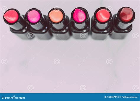 Group Of Red Pink And Nude Lipsticks With Different Colors And Textures Lined Up And Shot Top
