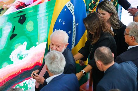 Janja ajuda Lula a caminhar em saída de evento no Planalto