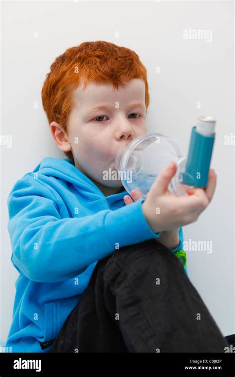 Little Boy Using His Asthma Inhaler To Alleviate Symptoms Stock Photo