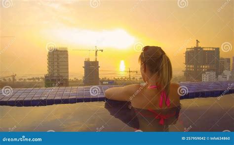 Cerrar Joven En Bikini Rosa Disfrutando De La Puesta De Sol Desde La Piscina De La Azotea