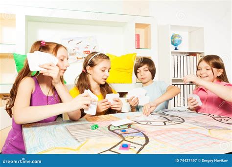 Four Friends Playing The Tabletop Game With Cards Stock Image Image