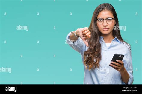 Young Beautiful Arab Woman Texting Using Smartphone Over Isolated