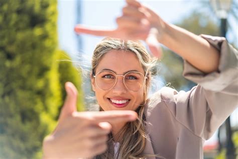 Eine hübsche blonde uruguayische Frau mit Brille im Freien mit einem glücklichen