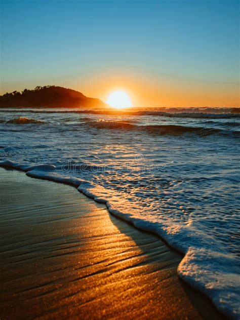 Colorful Ocean Beach Sunrise With Deep Blue Sky And Sun Rays Stock