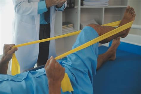 Premium Photo | Male patient using elastic band while doing physical ...