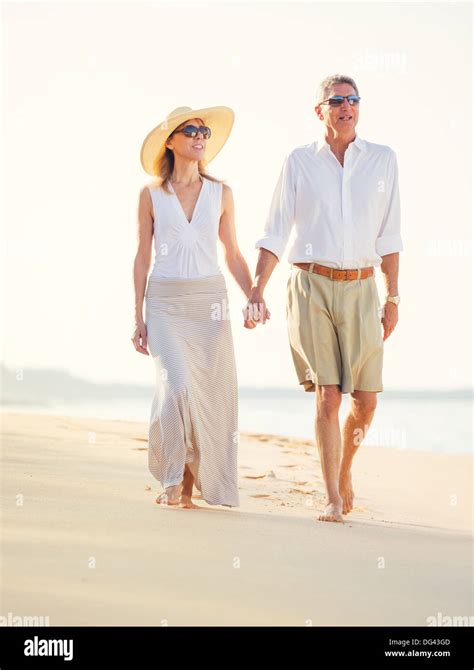 Happy Romantic Middle Aged Couple Enjoying Walk On The Beach Vacation