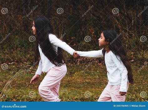 Side View Of Sisters Holding Hands While Walking On Field Stock Image