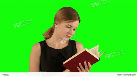 Young Beautiful Girl Reading A Book On Laptop On A Green Screen Chroma