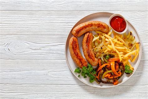 Salchichas A La Parrilla Pimientos Cebolla Y Patatas Fritas Foto De