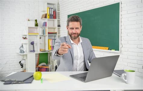 Profesor De Escuela Sonriente En El Aula Con Computadora En La Pizarra