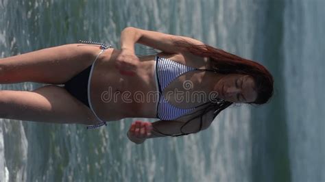 Caucasian Woman In Bikini Walking On Beach Knee Deep In Water Of