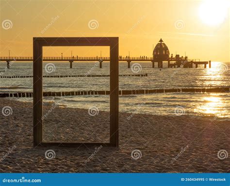 Giant Frame Border on a Sandy Beach with a Pier in the Background during Sunset Stock Image ...