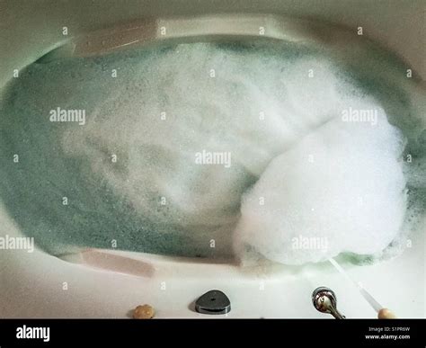 Bathtub full of bubbles with running water Stock Photo - Alamy