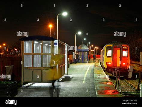 Train departing small railway station at night Stock Photo - Alamy