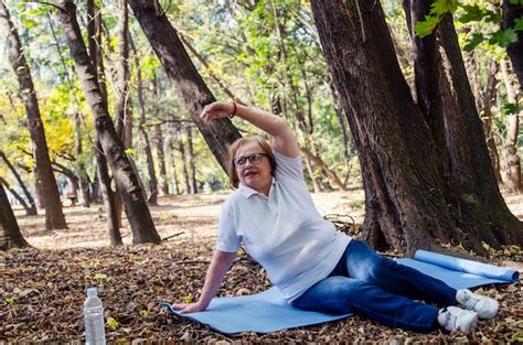 Premium Photo Old Senior Woman Stretching On Yoga Mat Outdoors In