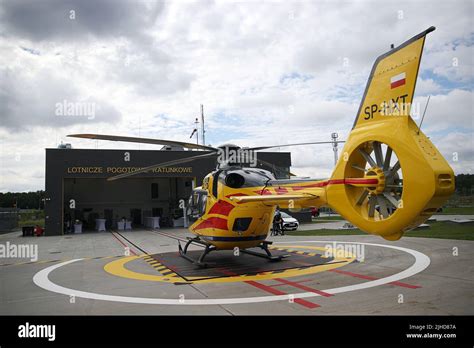 An emergency medical helicopter on a landing pad with the air ambulance building in the ...