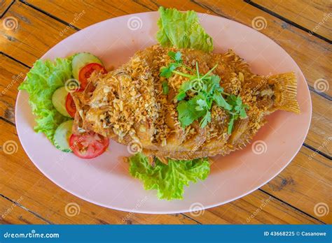 Pescados Rojos Fritos De La Tilapia Con Ajo Curruscante En La Tabla De