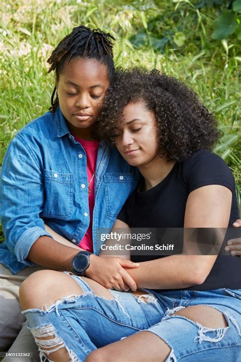 A Young Black Lesbian Couple Sitting In The Grass Eyes Closed High Res