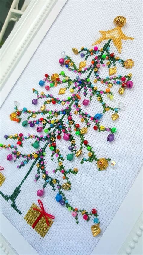 a cross stitch christmas tree with ornaments on it