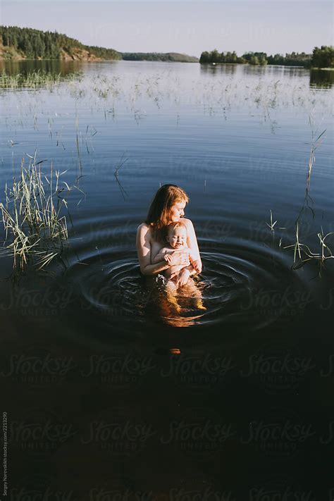 "Mother With Baby Swimming In Lake" by Stocksy Contributor "Sergey Narevskih" - Stocksy